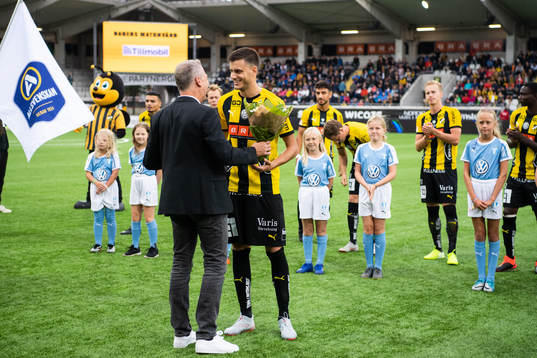 Häckens sportchef Sonny Karlsson delar ut blommor till Alexander Jeremejeff för att fira att han gör sin hundrade match