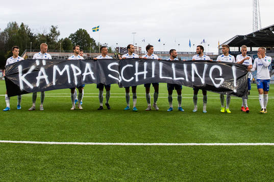 IFK Norrköpings spelare med en banderoll till stöd för
