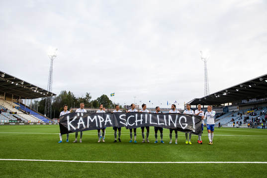IFK Norrköpings spelare med en banderoll till stöd för