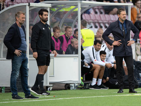s tränare Rikard Norling på samma bild som  AFC Eskilstunas tränare Nemanja Miljanovic, däremellan fjärdedomare Ozan Camlibel under fotbollsmatchen i Allsvenskan mellan AFC Eskilstuna och AIK den 11 augusti i Eskilstuna.