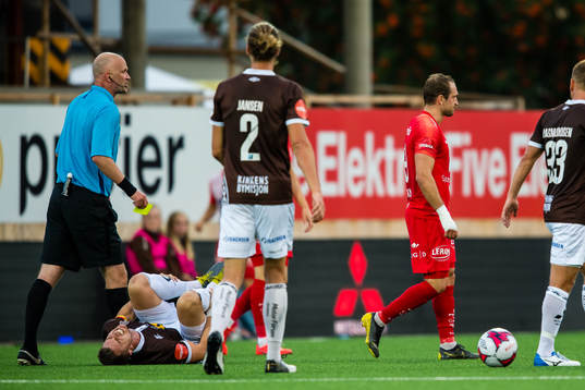 Christian Andreas Gauseth of Mjøndalen in pain while Veton Berisha of Brann gets a yellow card by Trond Ivar Døvle, referee,