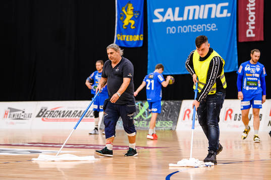 Funktionärer rengör golvet från kondens