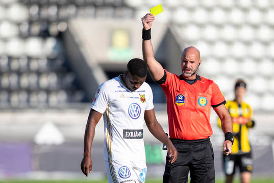 domare Stefan Johannesson delar ut gult kort till