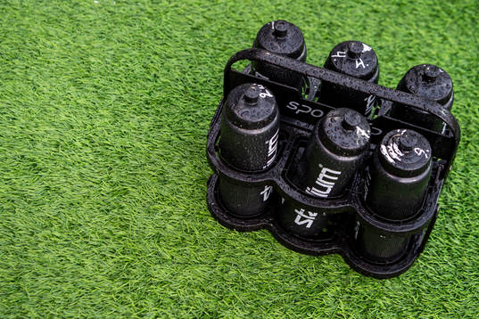 Vattenflaskor i ett ställ på konstgräs