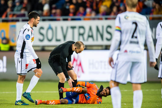 Marcos Vales Gonzalez of Sandefjord, Christian Moen, referee, and Erikson Spinola Lima of Aalesund in pain