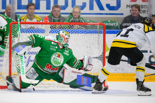 Rögles målvakt Roman Will räddar ett skott från Brynäs