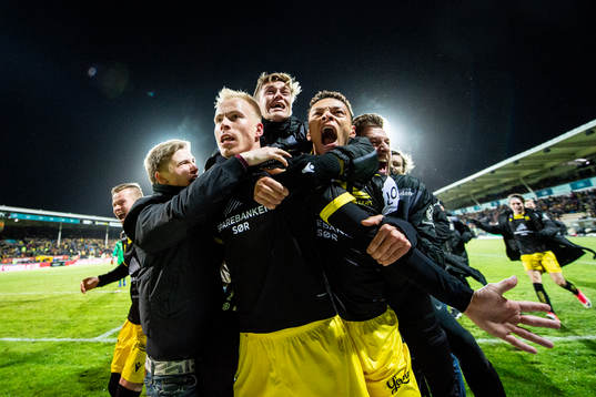 Martin Ramsland of Start celebrates with Mathias Idsøe Bringaker, Isaac Twum and teammates after scoring 4-3 during the Eliteserien playoff football match between Lillestrøm and Start on December 11, 2019 in Lillestrøm.
