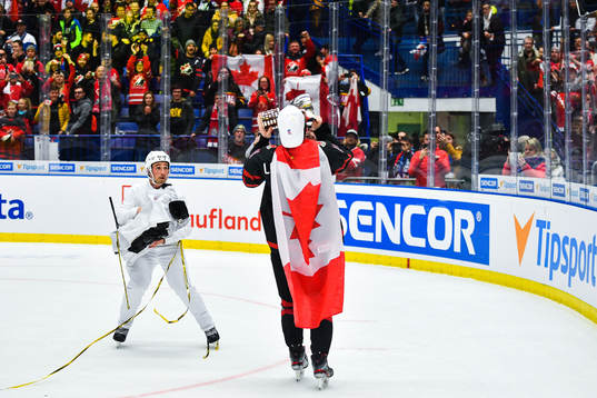 Alexis Lafreniere of Canada celebrate with the trophy and a