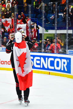 Alexis Lafreniere of Canada celebrate with the trophy and a