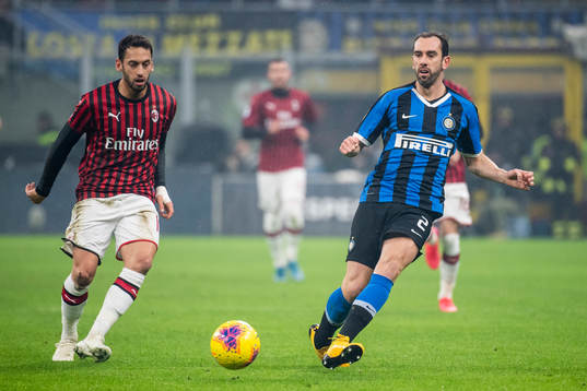 Hakan Calhanoglu of Milan and Diego Godin of Inter