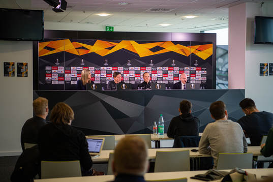 Members of the media listen to a press conference with