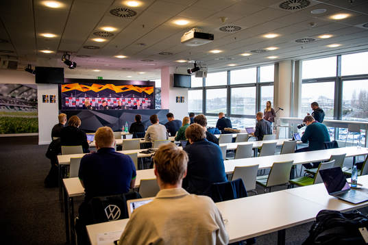 Members of the media listen to a press conference with