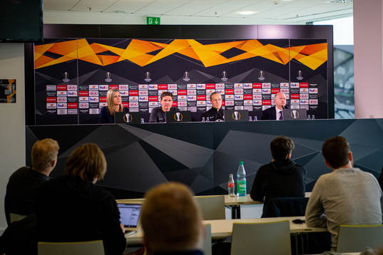 Members of the media listen to a press conference with