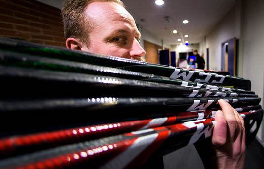 Färjestads materialare Arto Mäntymäki bär ut klubbor