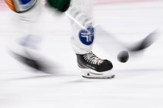 Panorerad bild på skridskor, puck och klubba