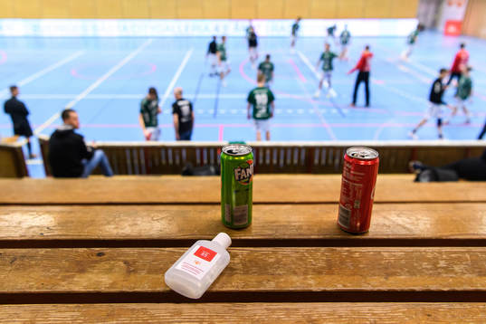En flaska handsprit och läskburkar på en tom läktare