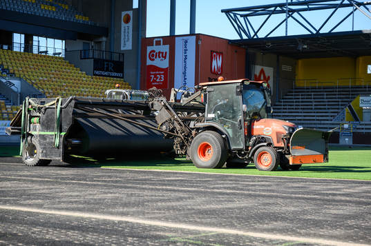 Man tar bort det gamla gräset vid byte av konstgräset på