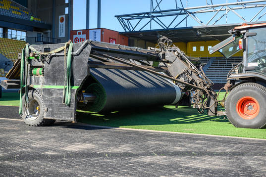 Man tar bort det gamla gräset vid byte av konstgräset på