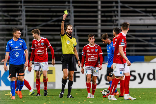 Umeås Deniz Yaldir tilldelas ett gult kort från domare Andreas Dufva-Johansson och i bakgrynden syns Dusan Djuric