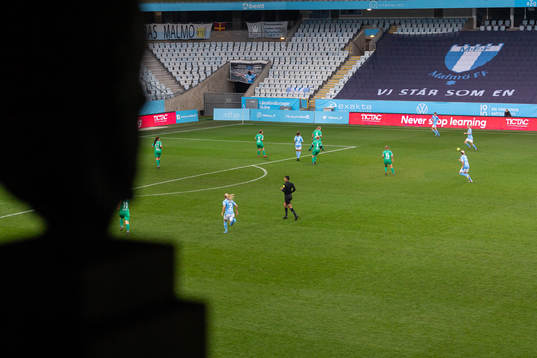 Interiör vy över Eleda Stadion sett från hederslogen med Eric Perssons staty i förgrunden