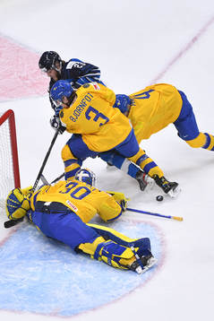 Hugo Alnefelt of Sweden makes a save as teammates Tobias