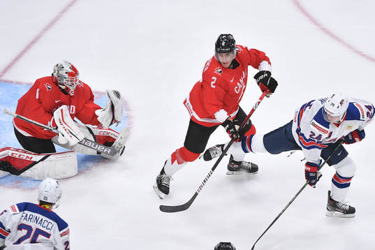 Devon Levi of Canada makes a save off a deflection from