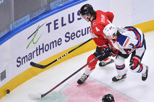 Bowen Byram of Canada protects the puck from Trevor Zegras