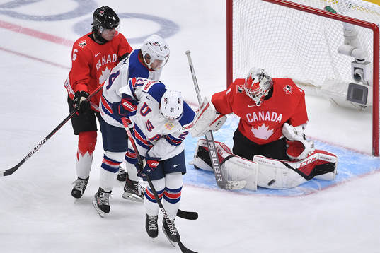 Devon Levi of Canada makes a save off a deflection from