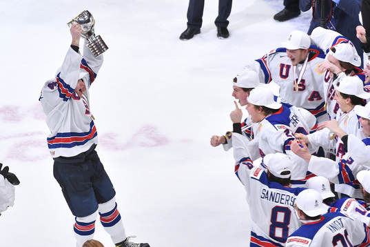 Cam York of USA brings the world junior championship trophy