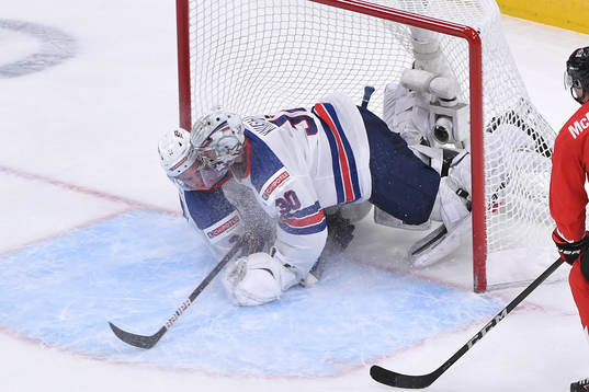 Drew Helleson of USA slides into his netminder Spencer