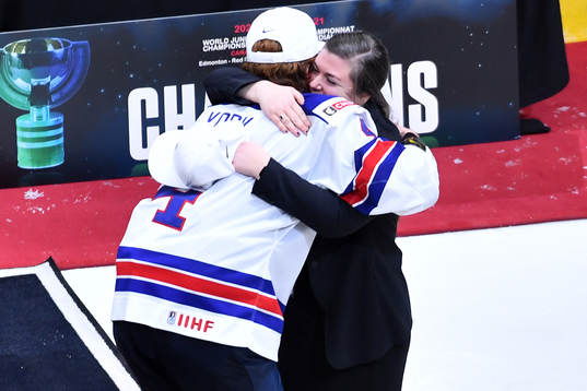 Team USA captain Cam York hugs video coach Theresa Feaster,