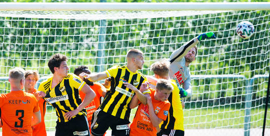 Kristianstads målvakt Calle Lindell boxar bort en hörna framför IFK Hässleholms Isak Orajärvi och Ivan Danielsson Andanovski i matchen i division 2 Södra Götaland mellan IFK Hässleholm och Kristianstads FC i Hässleholm 5 juni 2021.
