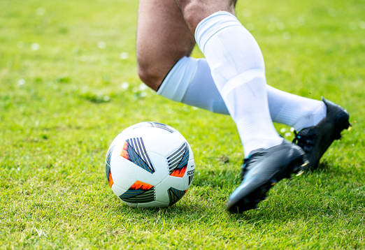 En fotbollsspelares ben och en boll