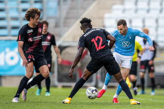 Malmö FFs Anders Christiansen driver med bollen mot Midtjyllands Nicolas Madsen och Fabrice
