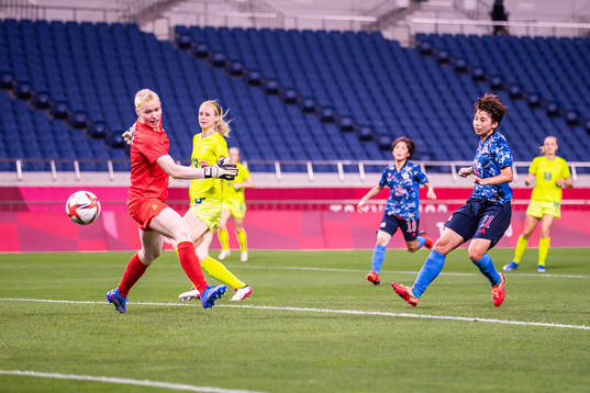 Mina Tanaka of Japan scores the 1-0 goal behind goalkeeper