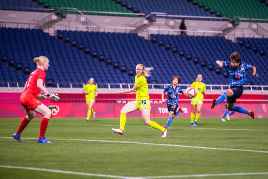 Mina Tanaka of Japan scores the 1-0 goal behind goalkeeper