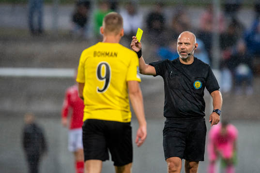 domare Robert Daradic delar ut ett gult kort