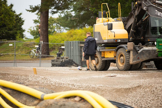 En funktionär hämtar en boll som sparkats över nätet
