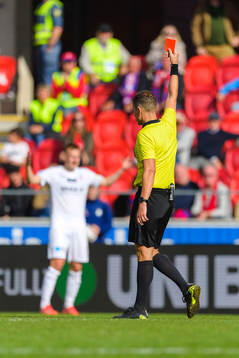 Domare Martin Strömbergsson med ett rött kort i handen