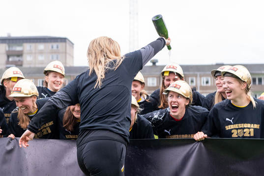 Häckens tränare Erika Faith häller champagne på spelarna