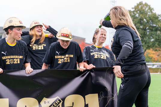 Häckens tränare Erika Faith häller champagne på spelarna