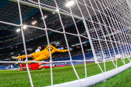 Karim Benzema of Real Madrid scores 1-1 behind goalkeeper