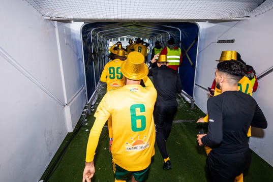 Dalkurds spelare springer ut genom spelartunneln och jublar