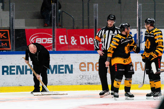 Vakmästare skrapar bort blod från isen