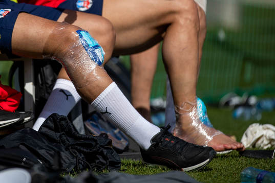 Ett knä och en fot med ispack