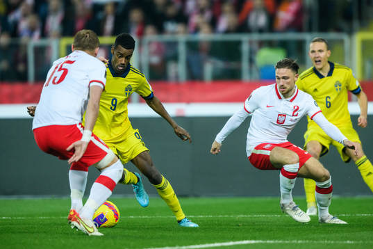 Alexander Isak of Sweden against Kamil Glik and Matty Cash of Poland