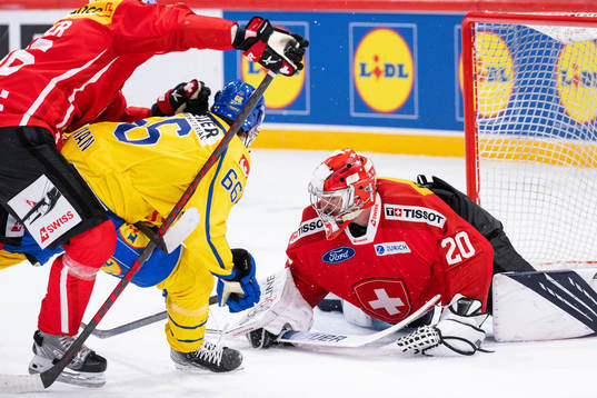 Nils Åman of Sweden against Goalkeeper Reto Berra of