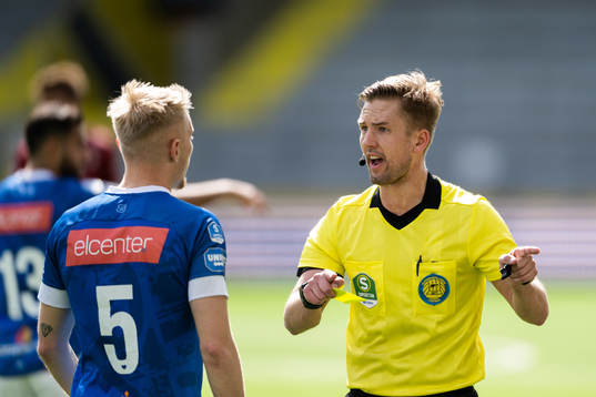 Domare Fredrik Hansson diskuterar med Norrbys Johan Brannefalk