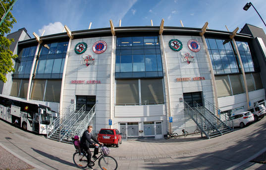 Örebros Martin Broberg cyklar förbi Behrn Arena exteriör