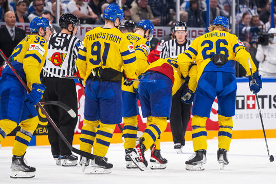 Emil Bemström of Sweden receives help off the ice from
